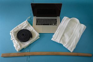 various martial arts attire and tools along with an apple laptop to find the top 5 martial arts resources
