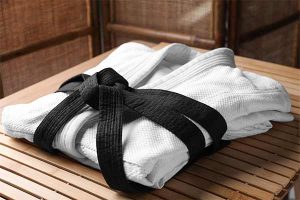 a black belt wrapped around a folded gi, attire used in all of the most popular styles of martial arts